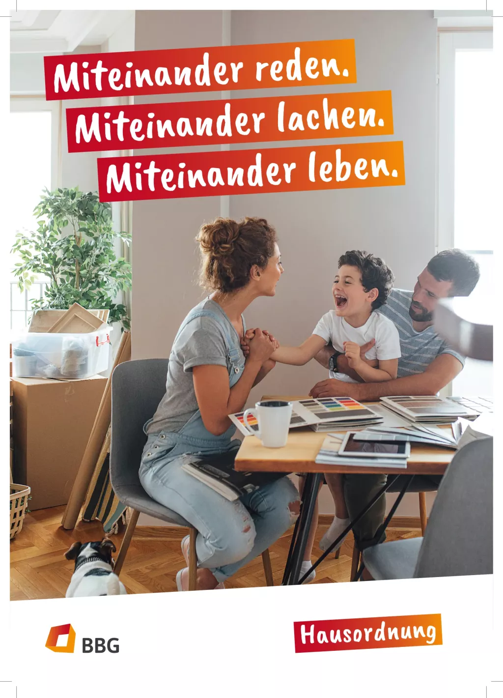Eine lächelnde Familie, die an einem Tisch in einem gemütlichen Haus miteinander spricht und lacht, mit Kisten und Pflanzen im Hintergrund.