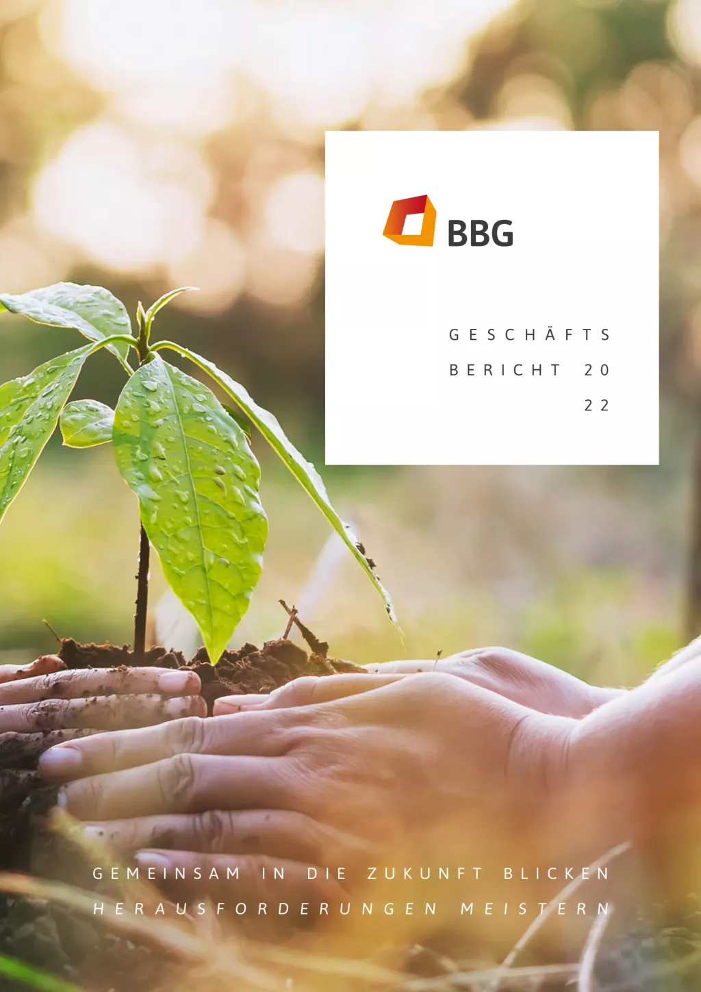 Zwei Hände schützen eine kleine Pflanze, die in der Erde wächst; rechts erscheint der Titel des Jahresberichts 2022 in deutscher Sprache.