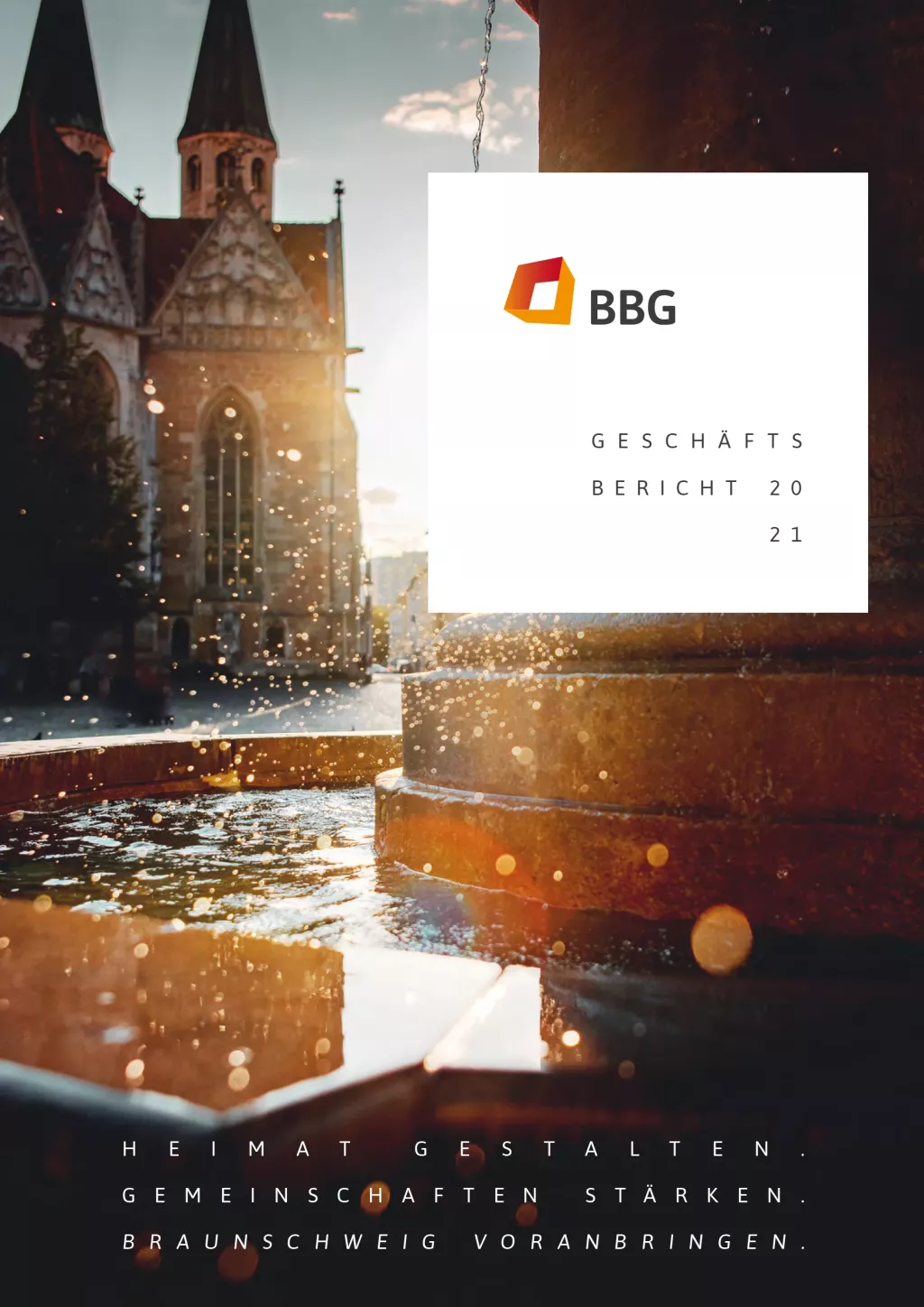 Ein Springbrunnen mit plätscherndem Wasser vor einer historischen Kirche bei Sonnenuntergang überlagert den Umschlagtext des BBG-Jahresberichts 2021.