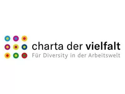 Beyaz zemin üzerine dokuz renkli nokta ve Charta der vielfalt - Für Diversity in der Arbeitswelt yazısından oluşan bir logo.