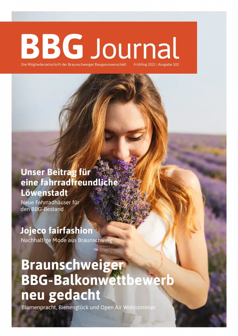 Eine Frau in einem weißen Kleid riecht an einem Strauß Lavendelblüten in einem lila Lavendelfeld.