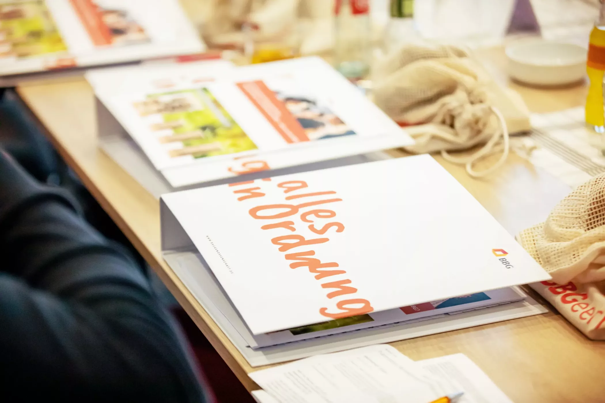 A folder on a desk with the inscription Everything in order in orange lettering, surrounded by papers and office supplies.